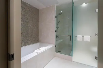 a bathroom with a tub and a glass shower at Sutton Place Hotel Toronto in Toronto