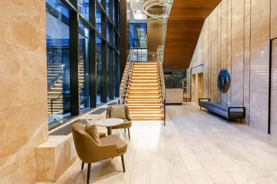 a lobby with a staircase and chairs and a table at Sutton Place Hotel Toronto in Toronto