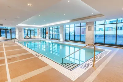 a swimming pool in a building with windows at Sutton Place Hotel Toronto in Toronto