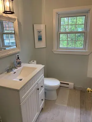 a bathroom with a sink and a toilet and a window at The Jypsy Inn - Journey Apartment Muskoka in Bracebridge