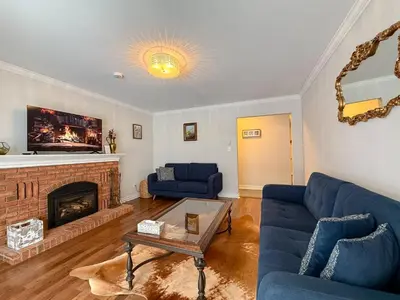 a living room with blue couches and a fireplace at The Promenade Cottage License # 002-2023 in Niagara on the Lake