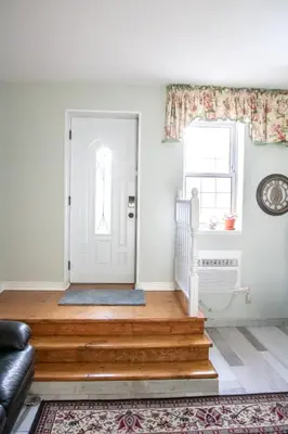 a living room with a white door and a rug at The Jypsy Inn / Fifth Avenue in Bracebridge