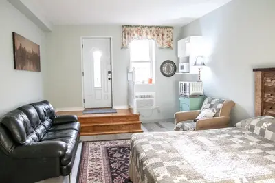 a bedroom with a bed and a couch and a chair at The Jypsy Inn / Fifth Avenue in Bracebridge