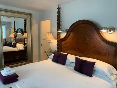 a bedroom with a large bed and a large mirror at 33 On Gage Garden Suite in Niagara on the Lake