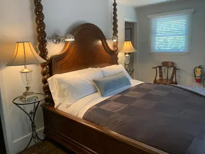a large bed with a wooden headboard in a bedroom at 33 On Gage Garden Suite in Niagara on the Lake