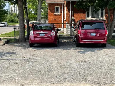 two red cars parked in front of a house at House in Niagara falls, Close to Clifton Hill, Casino and Horseshoe falls and with kitchen for 6 Guest in Niagara Falls