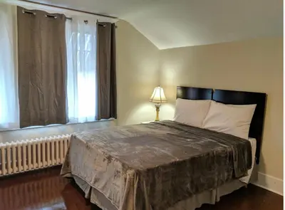 a bedroom with a large bed and a window at House in Niagara falls, Close to Clifton Hill, Casino and Horseshoe falls and with kitchen for 6 Guest in Niagara Falls