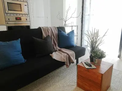 a living room with a black couch and a table at Stylish Downtown Toronto Residential Hotel in Toronto