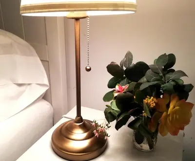a lamp sitting on a table next to a vase of flowers at Stylish Downtown Toronto Residential Hotel in Toronto