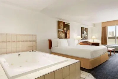 a hotel room with a bed and a bath tub at Days Inn by Wyndham Niagara Falls Centre St By the Falls in Niagara Falls