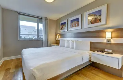 a hotel room with a large bed and a window at Town Inn Suites Hotel in Toronto