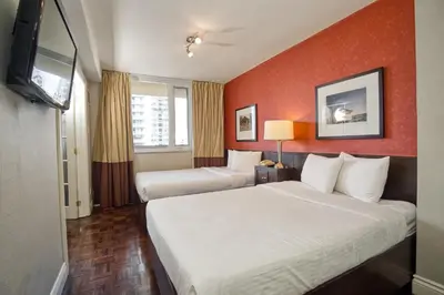 a hotel room with two beds and a flat screen tv at Town Inn Suites Hotel in Toronto