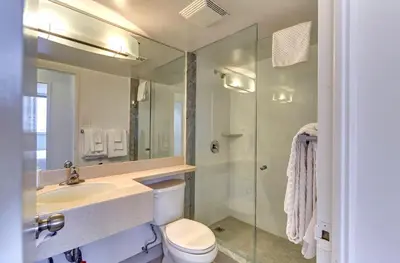 a bathroom with a toilet and a sink and a shower at Town Inn Suites Hotel in Toronto