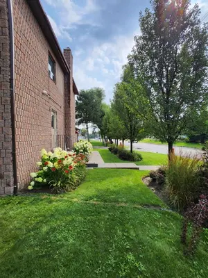 a brick building with a yard with flowers at Canadas Best Value Inn-Richmond Hill in Richmond Hill