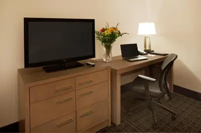a room with a desk with a television and a chair at Canadas Best Value Inn Toronto in Toronto