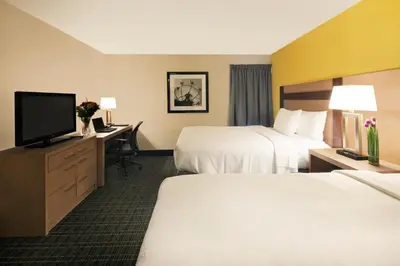 a hotel room with two beds and a flat screen tv at Canadas Best Value Inn Toronto in Toronto