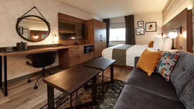 a hotel room with a bed and a desk at Stay Inn Hotel Toronto in Toronto