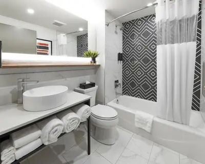 a white bathroom with a sink and a toilet at Stay Inn Hotel Toronto in Toronto