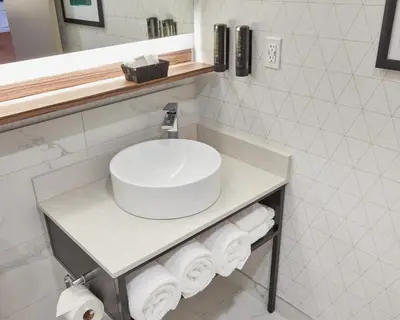 a bathroom with a sink and towels on a counter at Stay Inn Hotel Toronto in Toronto