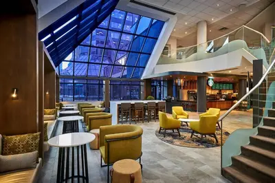 a lobby with tables and chairs and a large window at Delta Hotels by Marriott Toronto Mississauga in Mississauga