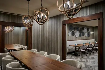 a dining room with tables and chairs and chandeliers at Delta Hotels by Marriott Toronto Mississauga in Mississauga