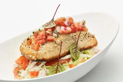 a white plate of food with fish and vegetables at Delta Hotels by Marriott Toronto Mississauga in Mississauga