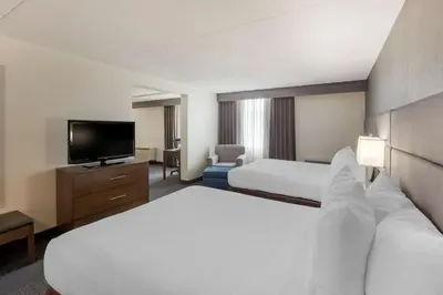a hotel room with two beds and a flat screen tv at Best Western Plus Toronto Airport Hotel in Mississauga