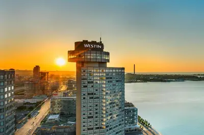 a building with a westin sign on the top at sunset at The Westin Harbour Castle, Toronto in Toronto