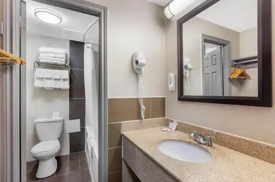 a bathroom with a toilet and a sink and a phone at Quality Inn Toronto Airport in Mississauga
