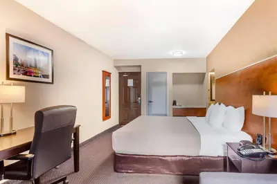 a hotel room with a large bed and a desk at Quality Inn Toronto Airport in Mississauga