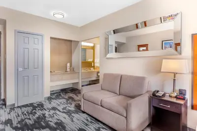 a living room with a couch and a mirror at Quality Inn Toronto Airport in Mississauga