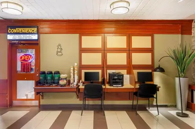 a restaurant with a counter with a microwave and chairs at Quality Inn Toronto Airport in Mississauga