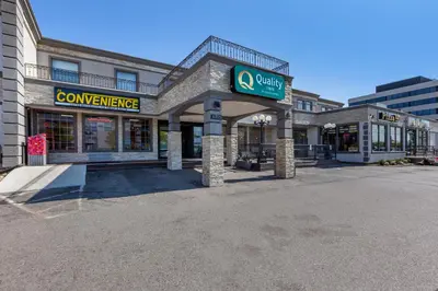 a building with a sign for a convenience store at Quality Inn Toronto Airport in Mississauga