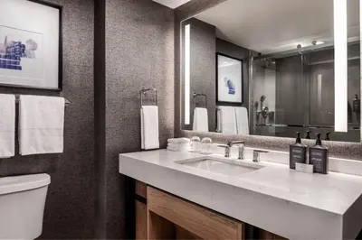 a bathroom with a sink and a toilet and a mirror at Sheraton Gateway Hotel in Toronto International Airport in Mississauga
