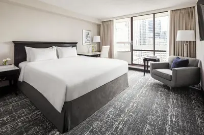 a hotel room with a large bed and a chair at Chelsea Hotel Toronto in Toronto