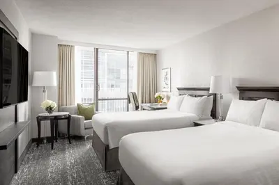 a hotel room with two beds and a television at Chelsea Hotel Toronto in Toronto