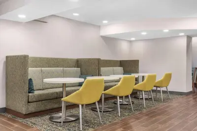 a waiting room with a couch and tables and chairs at Hampton Inn & Suites by Hilton Toronto Downtown in Toronto