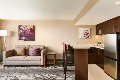 a kitchen and a living room with a couch and a table at DoubleTree by Hilton Hotel Toronto Airport West in Mississauga