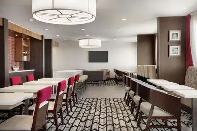 a dining room with tables and chairs and a tv at DoubleTree by Hilton Hotel Toronto Airport West in Mississauga