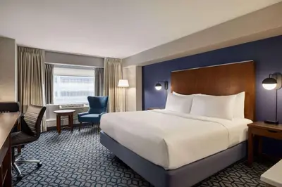 a hotel room with a large bed and a desk at Wyndham Grand Fallsview Hotel in Niagara Falls