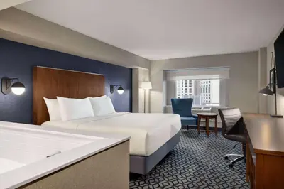 a hotel room with a bed and a desk at Wyndham Grand Fallsview Hotel in Niagara Falls