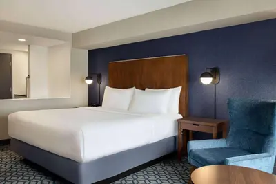 a hotel room with a bed and a chair at Wyndham Grand Fallsview Hotel in Niagara Falls