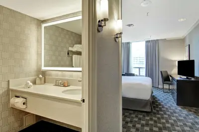 a bathroom with a bed and a sink and a mirror at DoubleTree by Hilton Toronto Downtown in Toronto