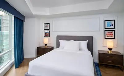 a bedroom with a large white bed and two lamps at Pantages Hotel Toronto Centre in Toronto