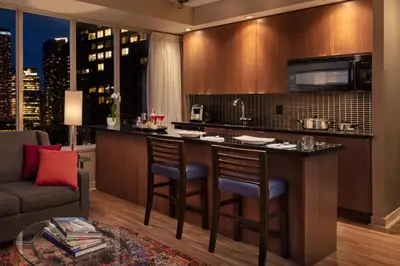 a kitchen with a bar with chairs and a couch at Executive Hotel Cosmopolitan Toronto in Toronto