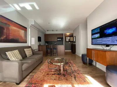 a living room with a couch and a table at Executive Hotel Cosmopolitan Toronto in Toronto
