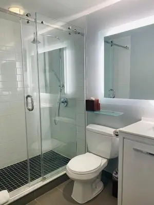 a bathroom with a toilet and a glass shower at Executive Hotel Cosmopolitan Toronto in Toronto
