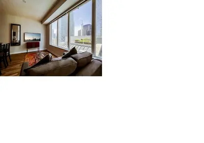 a living room with a couch and a large window at Executive Hotel Cosmopolitan Toronto in Toronto