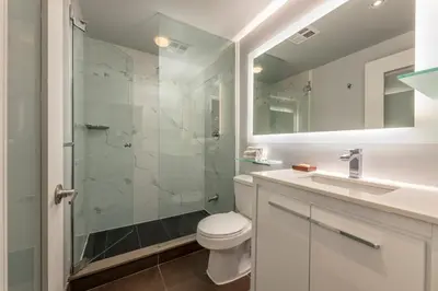 a bathroom with a shower and a toilet and a sink at Executive Hotel Cosmopolitan Toronto in Toronto
