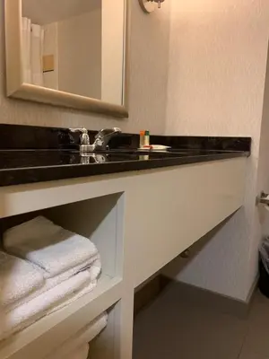a bathroom with a sink and a mirror and towels at Ramada by Wyndham Niagara Falls/Fallsview in Niagara Falls